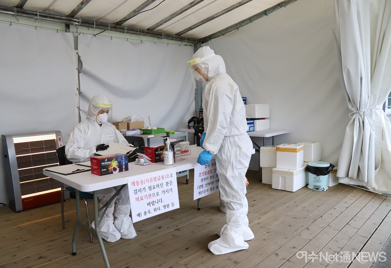 ▲11일 여수시 선별진료소에서 근무중인 역학조사반원과 검사반원이 얘기를 나누고 있다.ⓒ오병종