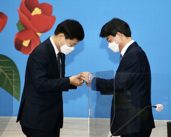 ▲ 두 교육감이 동백 뱃지를 교환하고 있다