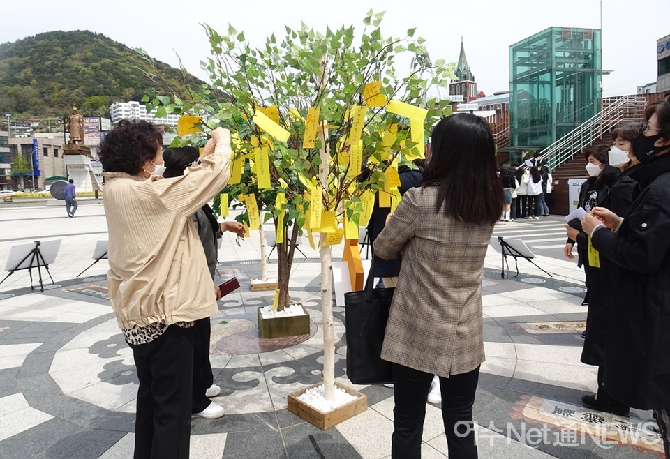 ▲시민들이 글귀를 완성해 추모나무에 매달고 있다. 추모나무는 매년 전시한다. 지난해에는 비가 와서 실내에 전시했다 ⓒ전시은