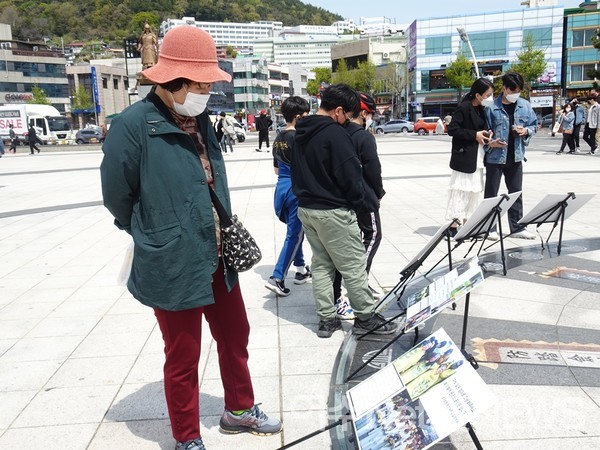 ▲세월호 참사 과정을 담은 판넬을 보고 있다 ⓒ전시은