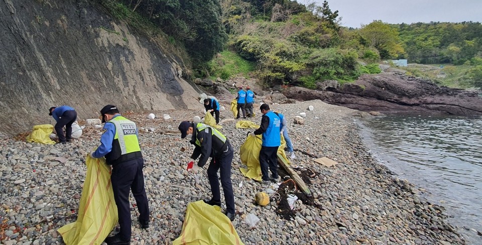 ▲해안가 쓰레기를 치우는 해경과 봉사단체 회원들