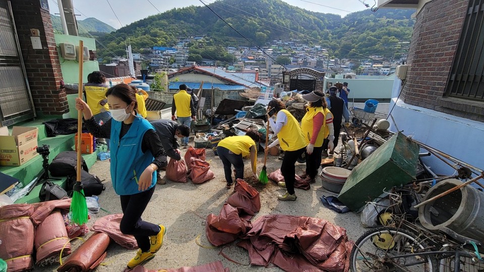 ▲봉사자와 주민센터 담당자가 쓰레기를 치우고 있다