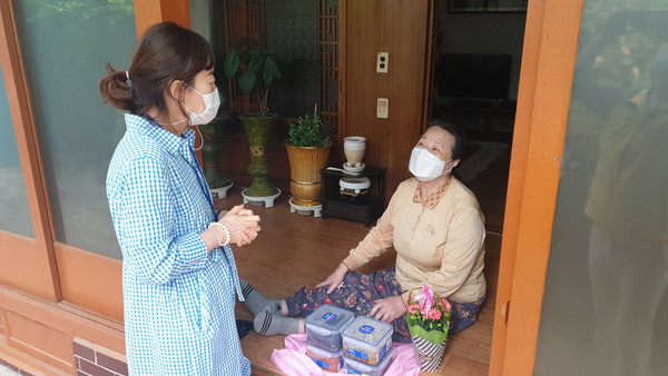 ▲동여수노인복지관 관계자들이 어르신에게 반찬과 카네이션을 전달했다