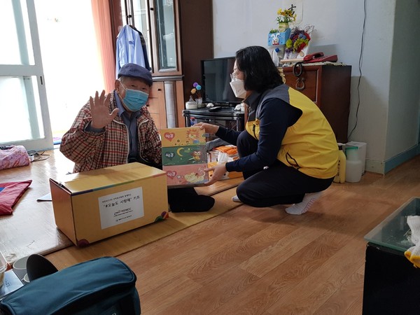 ▲동여수노인복지관 관계자들이 어르신에게 반찬과 카네이션을 전달했다