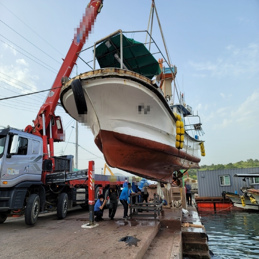 ▲ 크레인을 이용해 어선을 육지로 인양하고 있다