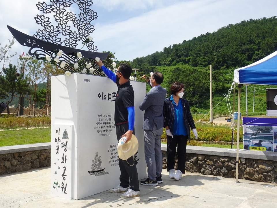 ▲조형물에 헌화하는 참여자들 ⓒ전시은