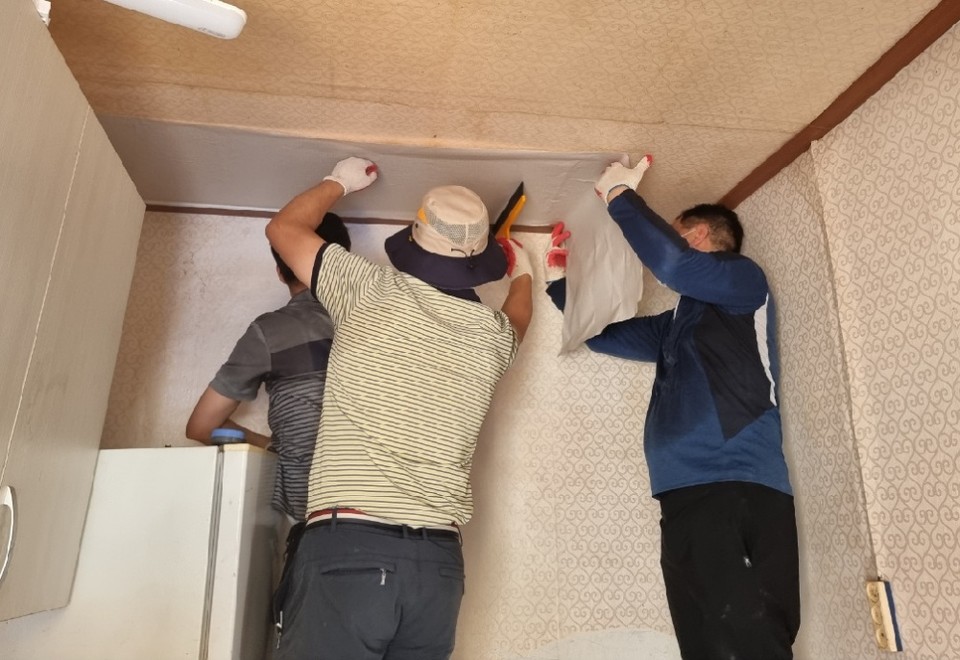 ▲기초수급자 가구를 방문해 집안을 새로 도배하고 있다