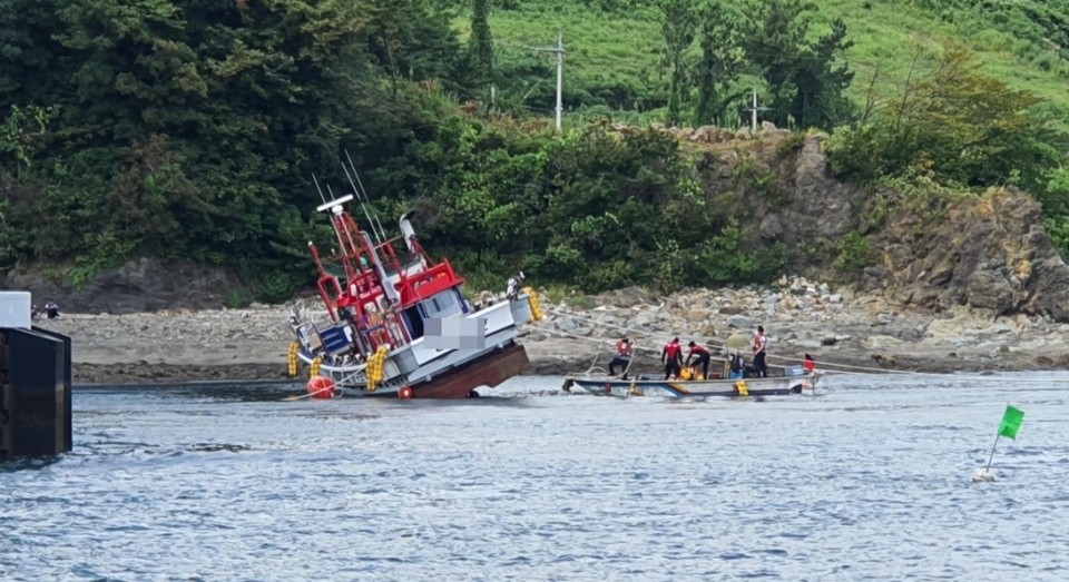 ▲해경이 좌초한 어선을 구조하고 있다