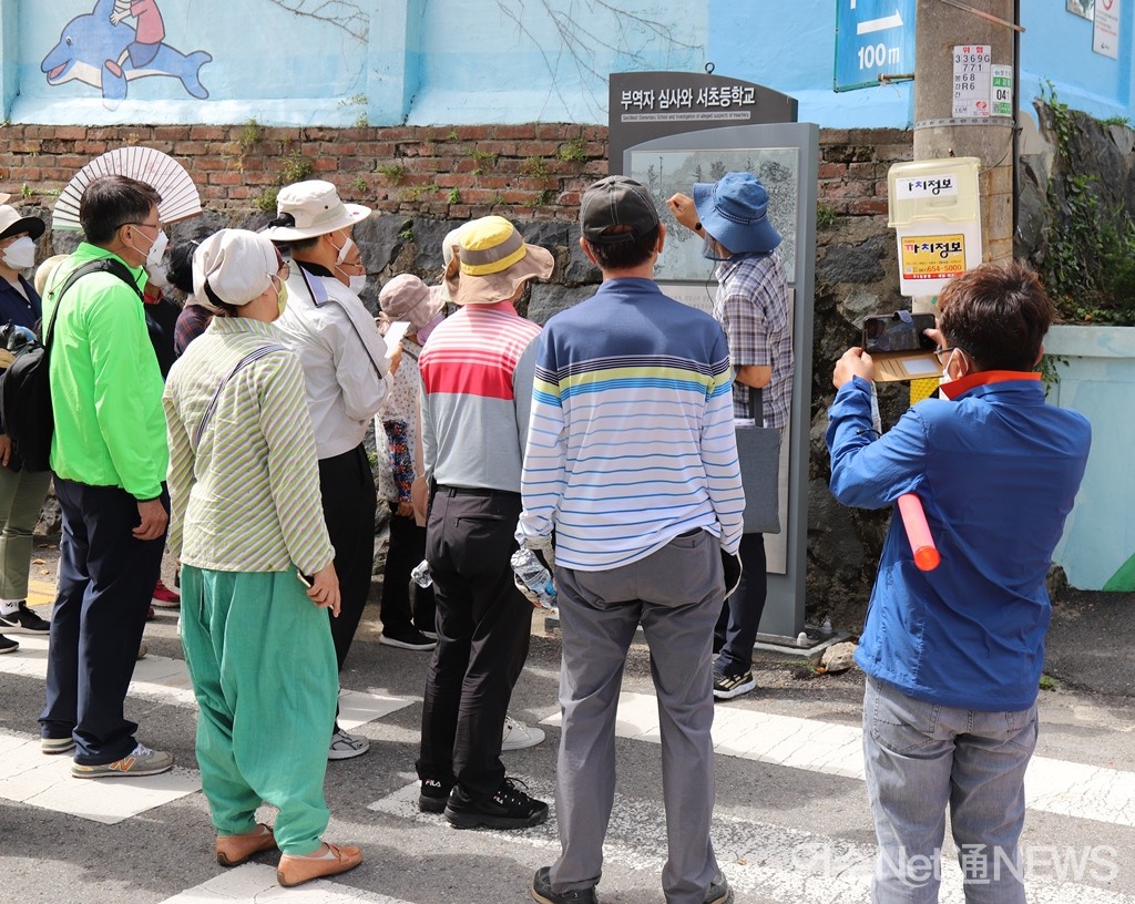 ▲답사팀이 여수서초등학교 앞의 '부역사 심사와 여수서초등학교'  여순사건 안내판을 보고 있다.  ⓒ오병종