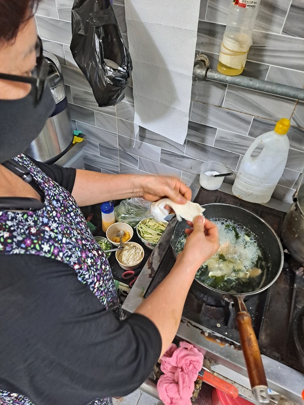 ▲남양분식 아주머니가 밀가루 반죽을 직접 손으로 뜯어서 넣어 수제비를 쑨다.  ⓒ조찬현