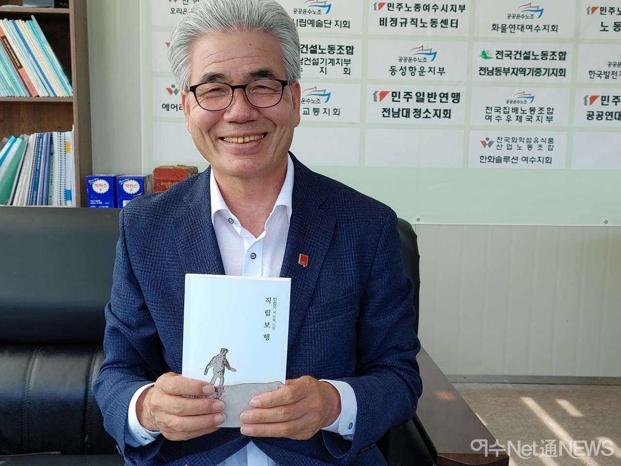 ▲ 민점기 시인이 그가 펴낸 세번째 시집 직립보행을 펼쳐보이고 있다