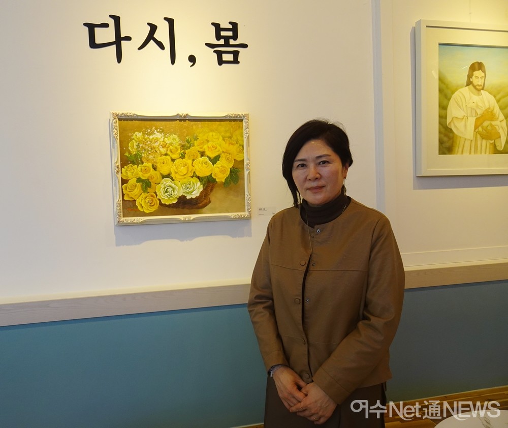 ▲여수여성미술작가회 김미옥 회장이 작품 '영원한 사랑' 앞에 서 있다