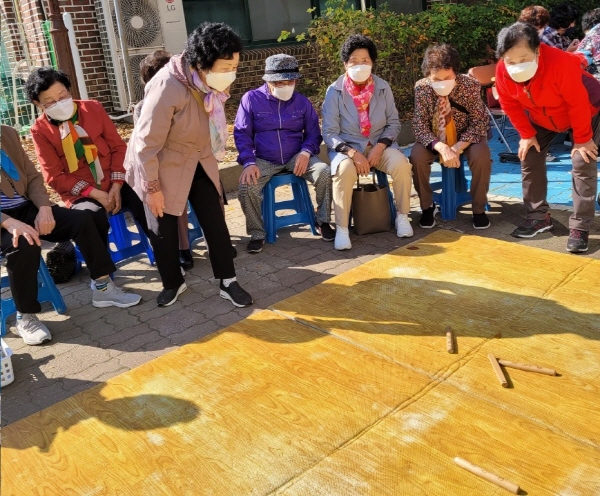 ▲ 행사에 참여한 어르신이 윷놀이를 진행하고 있다