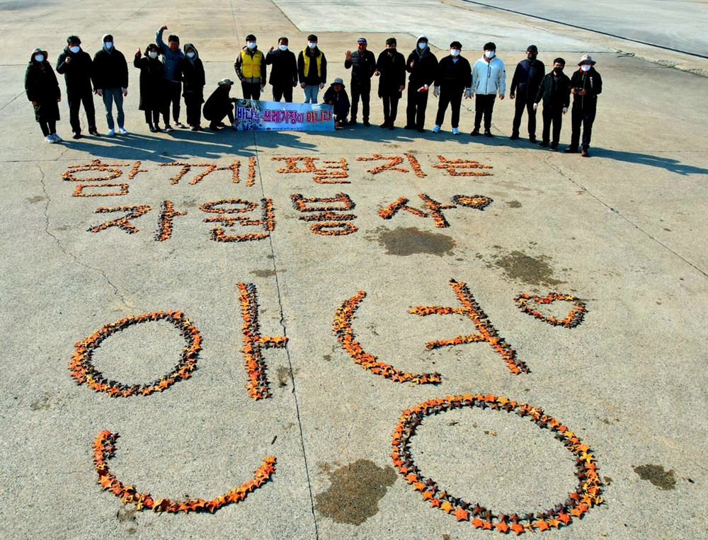 ▲해양정화활동 참여자들이 수거한 불가사리로 글자를 만든 후 기념사진을 찍고 있다 ⓒ박근호