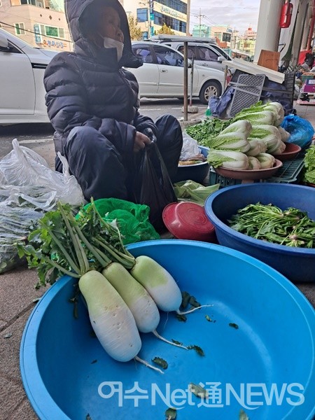 ▲ 만성리에서 직접 농사지어 농산물을 가져왔다는 한 할머니가 무와 배추를 사가라며 손님에게 권한다.ⓒ조찬현