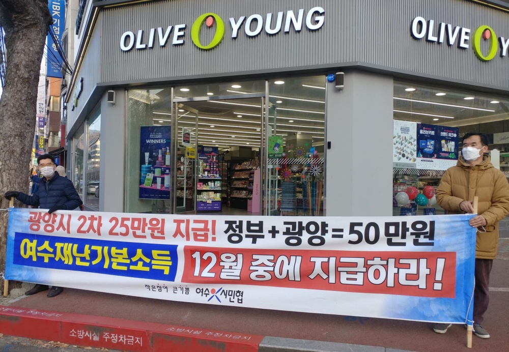 ▲펼침현수막을 들고 재난지원금 지급을 촉구하는 시민들. ⓒ여수시민협