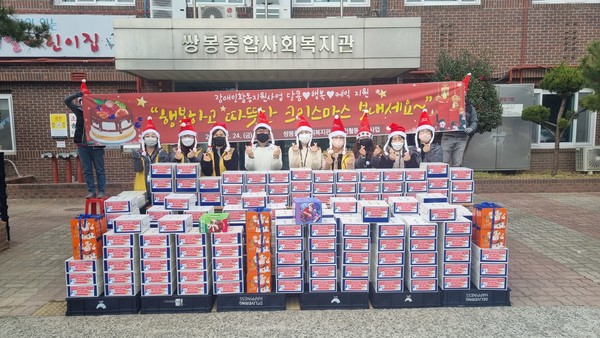 ▲쌍봉복지관 직원들이 크리스마스 케익과 함께 기념사진을 찍고 있다