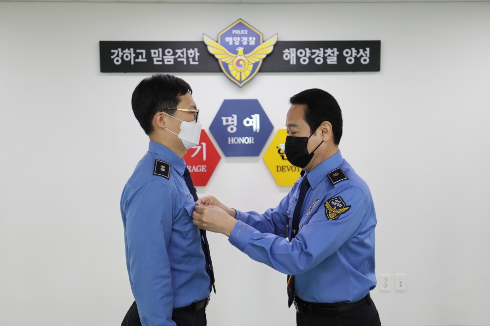 ▲여인태 교육원장이 신규 교수요원에게 교수 표장을 달아주고 있다.