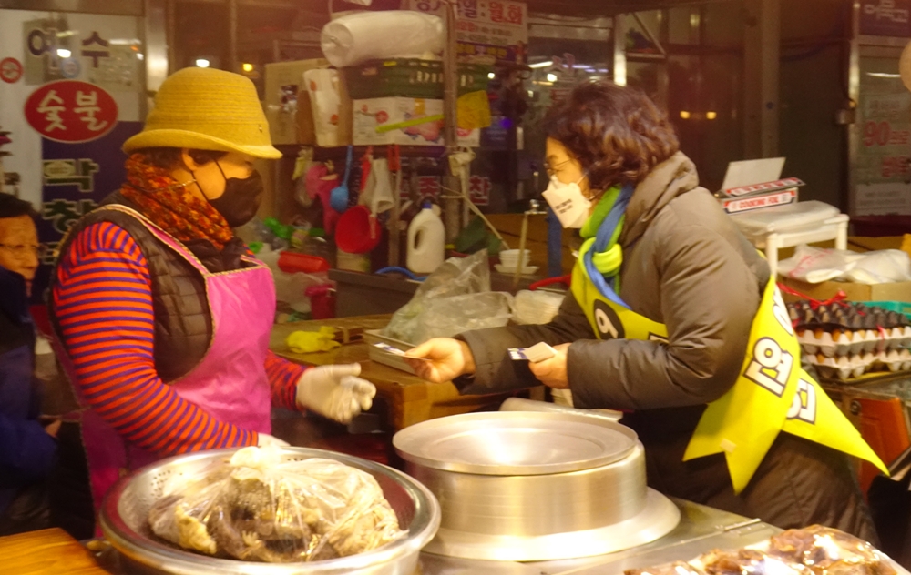  ▲정우영 씨가 시장 상인에게 명함을 전하고 있다