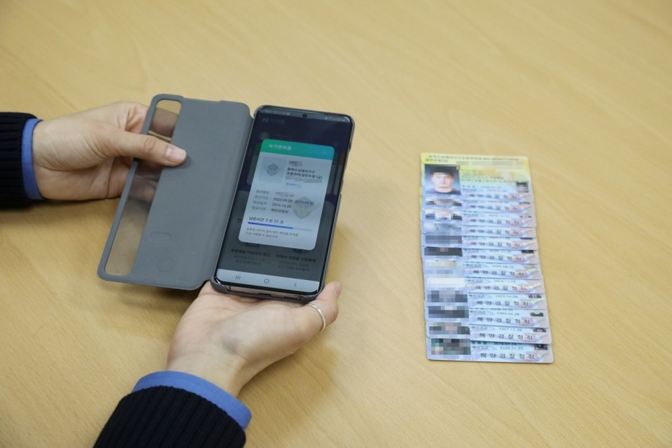 ▲핸드폰에 보이는 모바일 수상레저조종면허증. 그 옆은 우편등기로 발송되는 면허증이다