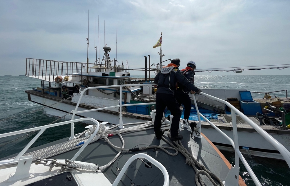▲경비함정이 어선 승선원 확인 및 검문검색을 위해 어선에 오르고 있다