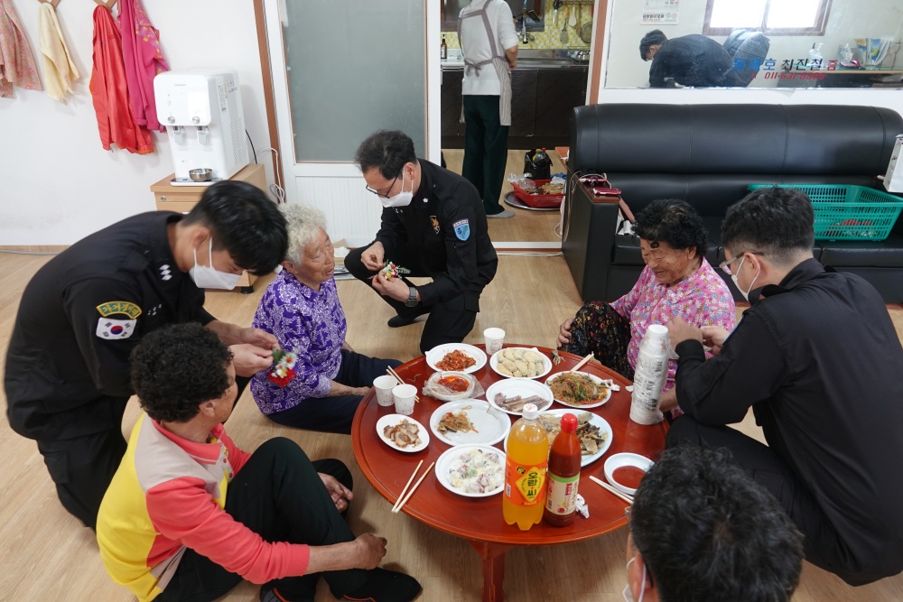 ▲ 가거경비대가 독거노인에게 꽃을 달아주고 있다.