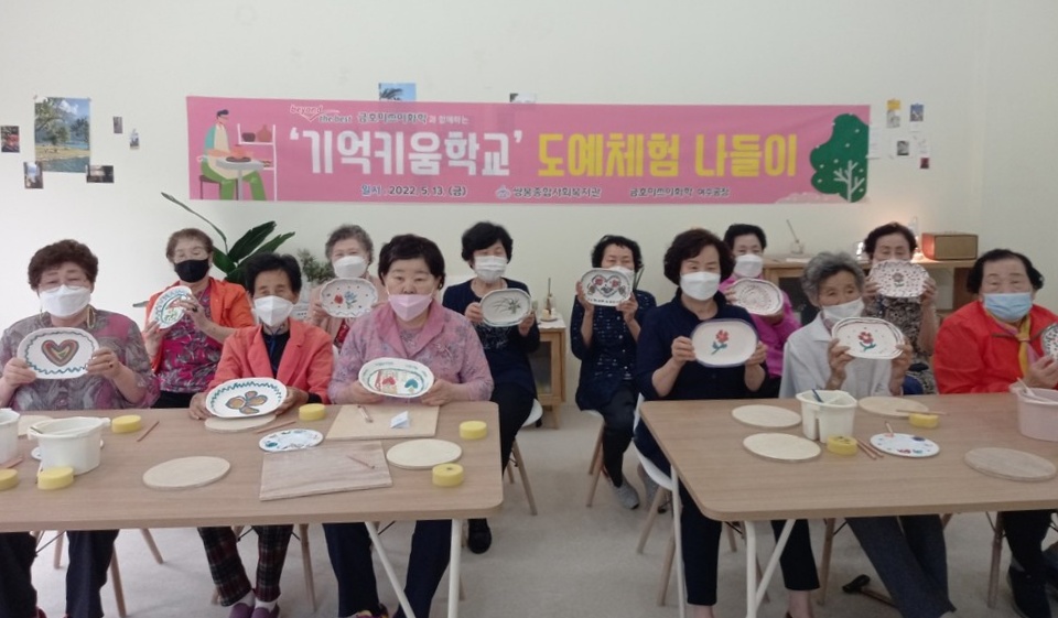 기억키움학교 어르신들이 도예체험으로 완성한 그릇을 들고 기념 사진을 찍고 있다. ⓒ쌍봉복지관