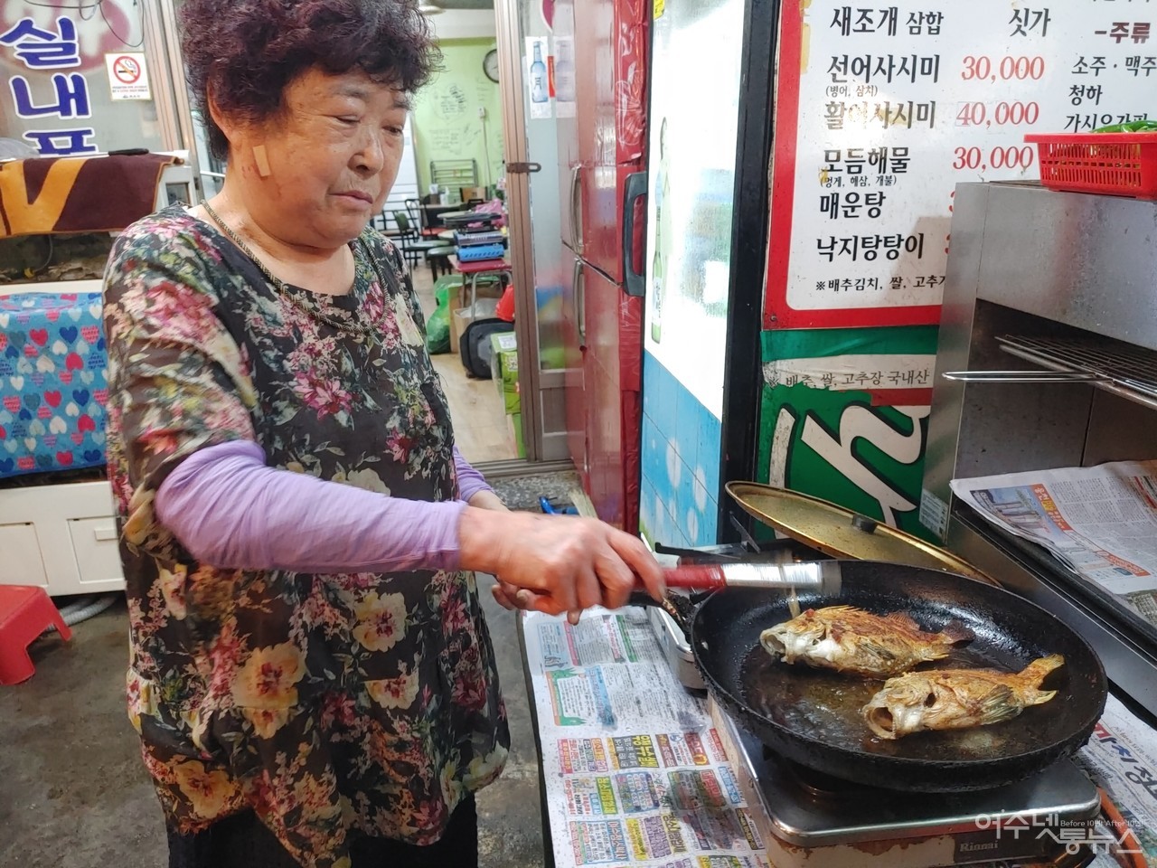 ▲ 21번 포차와 지근거리에 있는 여수삼합의 원조로 알려진 24번 포차 박삼래(75세)씨가 금풍생이를 굽고 있다 ⓒ심명남