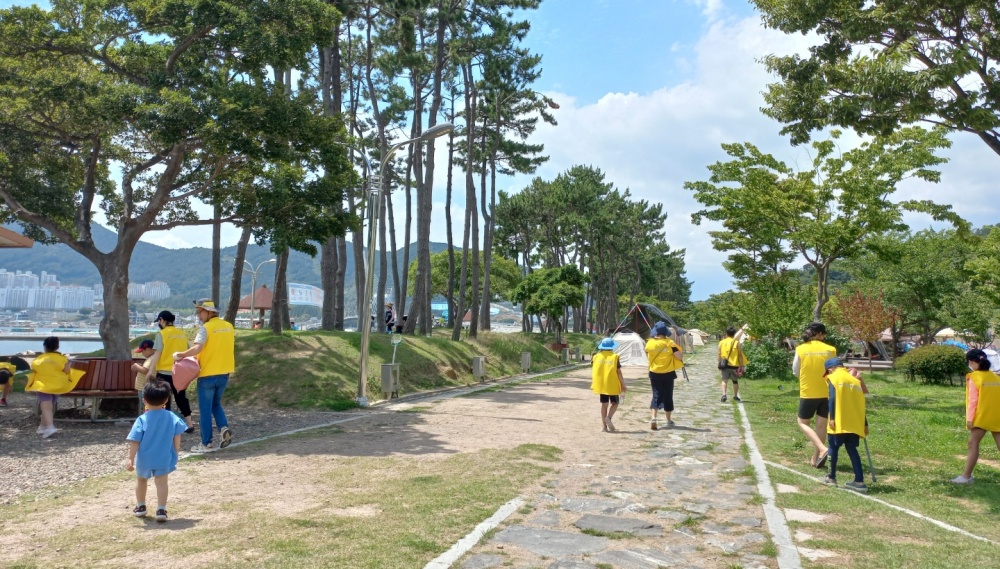 ▲ 가족봉사단이 쓰레기를 줍고 있다.