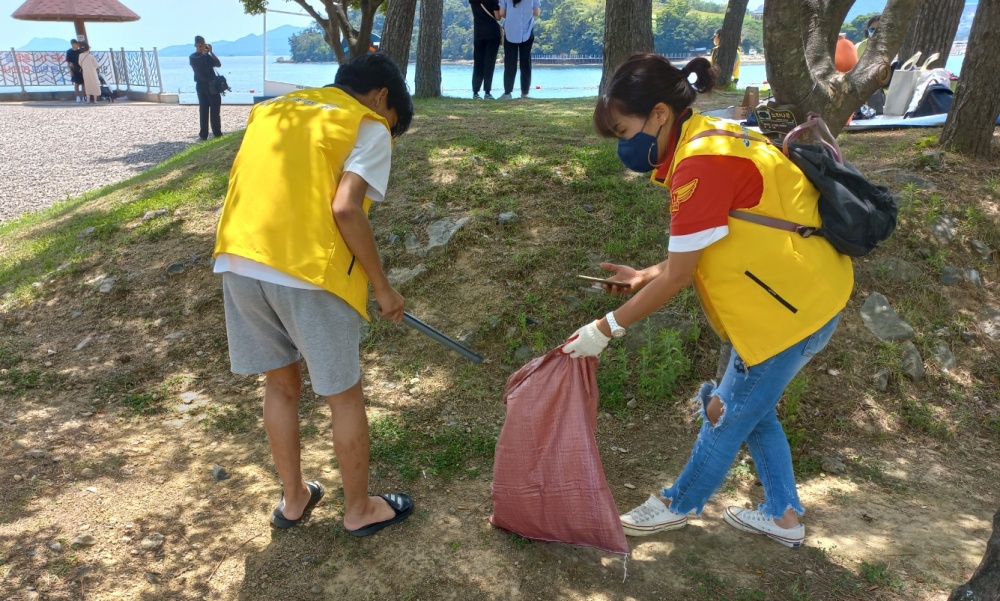 ▲ 가족봉사단이 쓰레기를 줍고 있다.