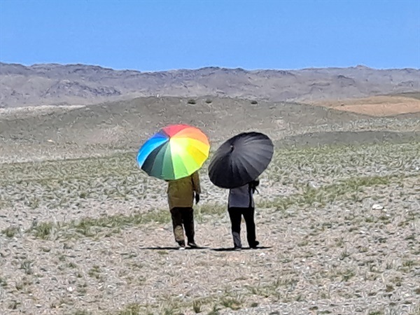 ▲ 고조선유적답사단 일행 중 두 명의 여성이 화장실을 가기 위해 우산을 쓰고 멀리 가고 있다. 몸을 가려줄 것 하나 없는 사막에서 화장실에 가기 위해서는 우산이 대안이 된다.  ⓒ오문수