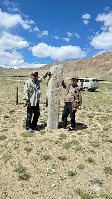 ▲일행을 안내한 몽골가이드 저리거(왼쪽)씨와 박인석씨가 몽골여행 중 만났던 소중한 사슴돌 옆에서 기념촬영했다. ⓒ오문수