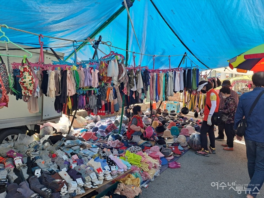 ▲29일 여수 장날. 연등천변의 노점에서 한 여자 손님과 상인이 머리에 쓰는 모자를 두고 흥정을 벌이고 있다.  ⓒ조찬현