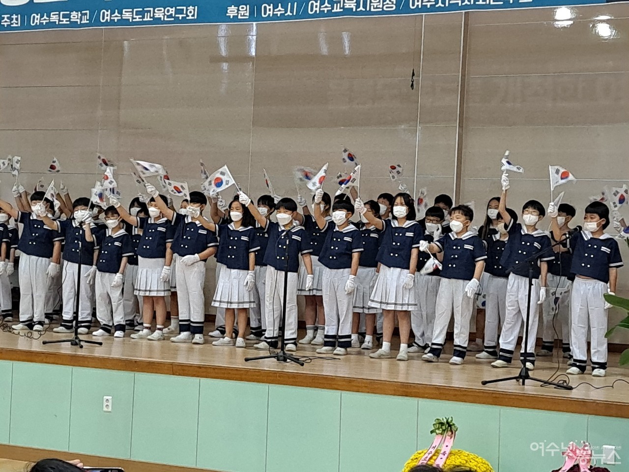 ▲ 울릉도·독도 개척한 여수 사람들 개막식 행사에 참여한 여수남초등학교 학생들이 홀로 아리랑 합창에 이어 태극기를 흔들며 환호하고 있다.ⓒ조찬현