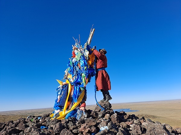▲   수흐바타르 아이막에서 왔다는 남성 두명이 오보위에 세워진 버드나무에 하닥을 고쳐 다시 건 후 오보주위를 돌며 우유를 뿌리고 있었다.ⓒ오문수