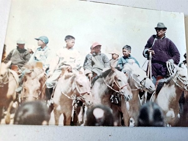 ▲   저리거씨 부인 '모기'씨의 막내 동생이 어릴적 나담축제에 참가해 승마경기에서 1등한 사진. 경기감독관이 결승선에 먼저 들어온 기수부터 순서대로 세웠다고 한다. 경기감독관 옆 말위에 앉아있는 어린이가 '모기'씨 막내동생이다. ⓒ "모기"씨 동생제공