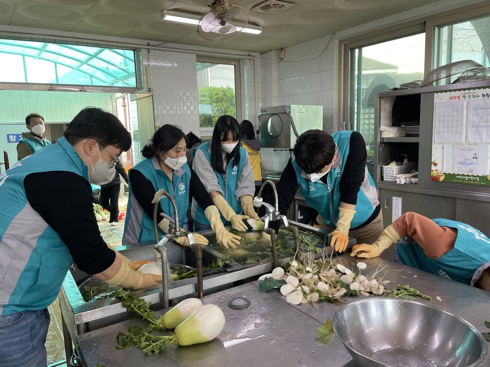 ▲GS칼텍스 인력개발부문 임직원들이 무를 씻고 있다. ⓒ쌍봉복지관