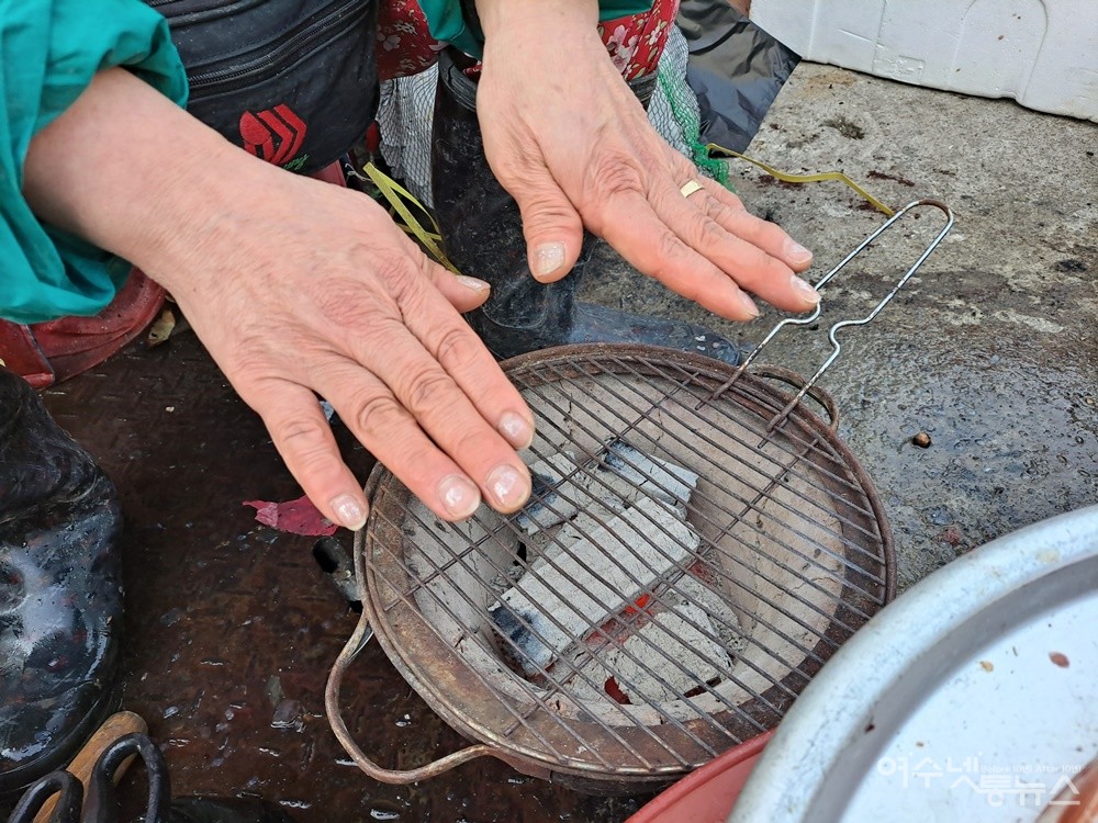 ▲유난히 추운 올겨울, 어머니는 시린 손을 숯화덕에서 녹이곤 한다.  ⓒ조찬현
