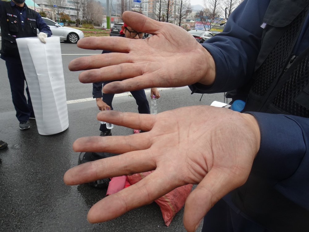 ▲ 까맣게 변한 노동자의 손