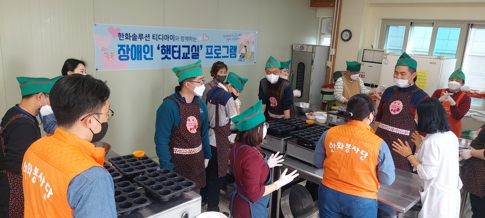 한화티디아이직원과 장애인햇터교실 이용자 분들이  빵만들기 전 오븐등 안전사고예방에 대해 설명을 듣고 있다.▲ ⓒ김연우