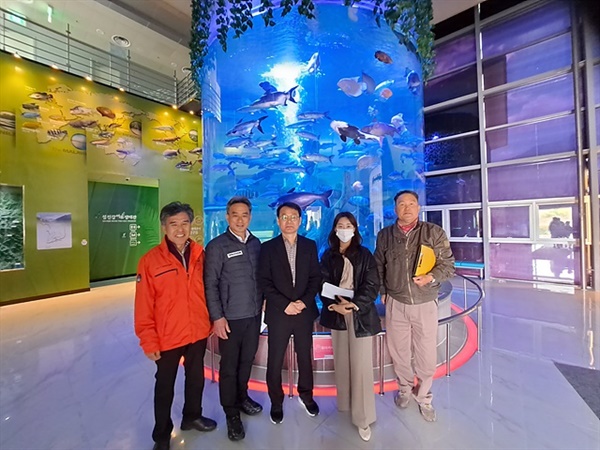 ▲ 섬진강어류생태관 대형 원통 열대어 수조 앞에서 조우현 관장(중앙)과 해양수산교육원 해양환경감시단 김호 위원장 일행이 기념촬영을 했다. 신현정 연구사에 의하면 