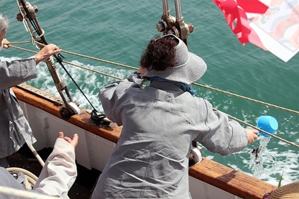 ▲  바다에 고기를 방생하는 송광사 신도 모습 ⓒ오문수