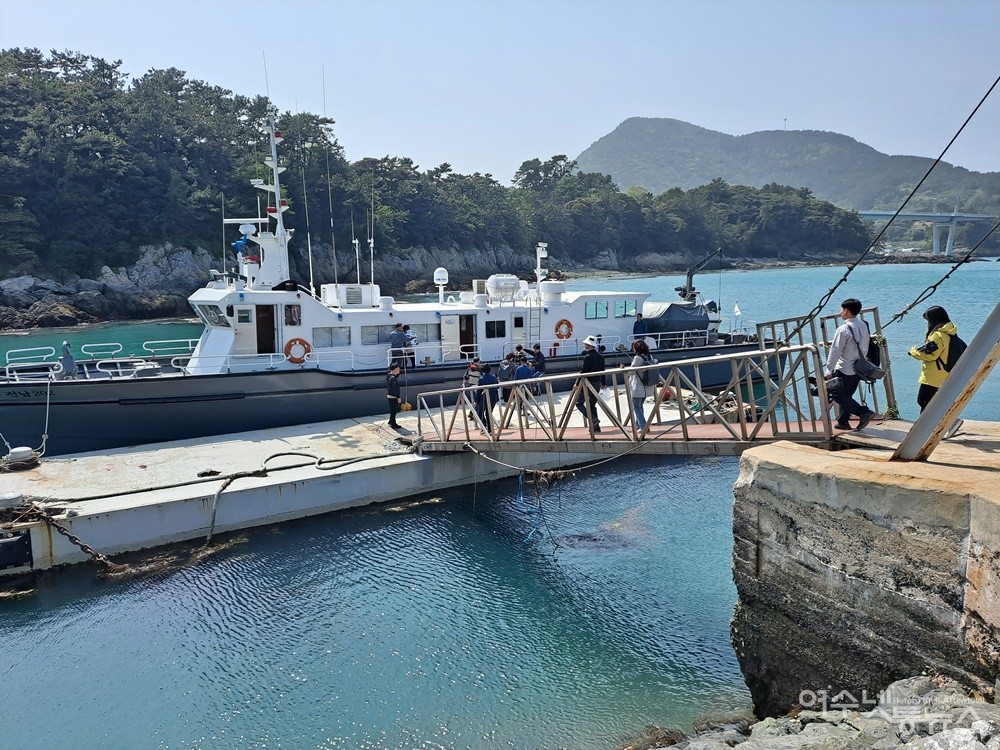 ▲여수시의회 미군폭격사건특별위원회 ‘찾아가는 현장 간담회’ 참여자들과 여수MBC 취재진이 남면 안도리 부두에서 관공선에 오르고 있다. ⓒ조찬현