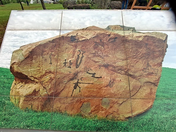 ▲ 화장동에 있는 고인돌 공원에 그려진 암각화 모습으로 돌칼 1점, 앉아있는 인물상과 서있는 인물상이 보인다. 역사 문화에 관심이 많은 고조선유적답사단원의 관심사항이기도 하다 ⓒ 오문수