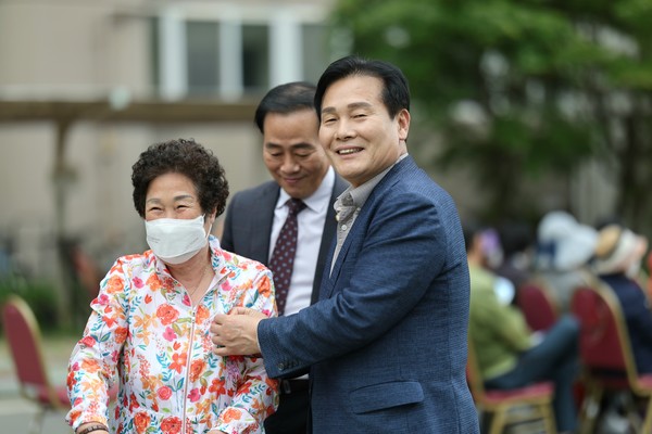 ▲ ⓒ 주철현 여수 갑 국회의원이 지역주민에게 카네이션을 달아주고 있다.