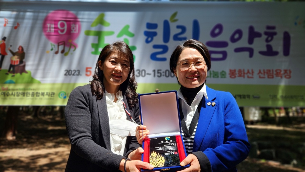 ▲ 민덕희 시의원이 공로패를 들고 기념사진을 찍고 있다.