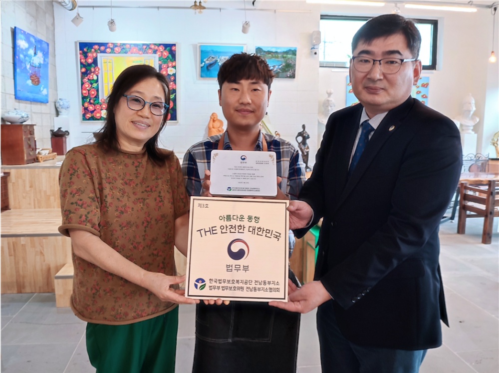 ▲ 미르마루갤러리&카페 김태원 대표(가운데)가 후원기업 현판과 인증패를 받고 있다.