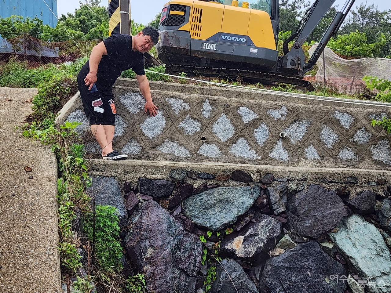 ▲ 박성미 의원 사비로 쌓은 석축을 이민재 전 이장이 가르키고 있다  ⓒ심명남