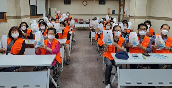 ▲ ⓒ  참여자 어르신들께서 혹서기대비 물품(보틀병, 파우치, 쿨스카프, 쿨토시)을 받고 단체사진을 촬영하고 있다.