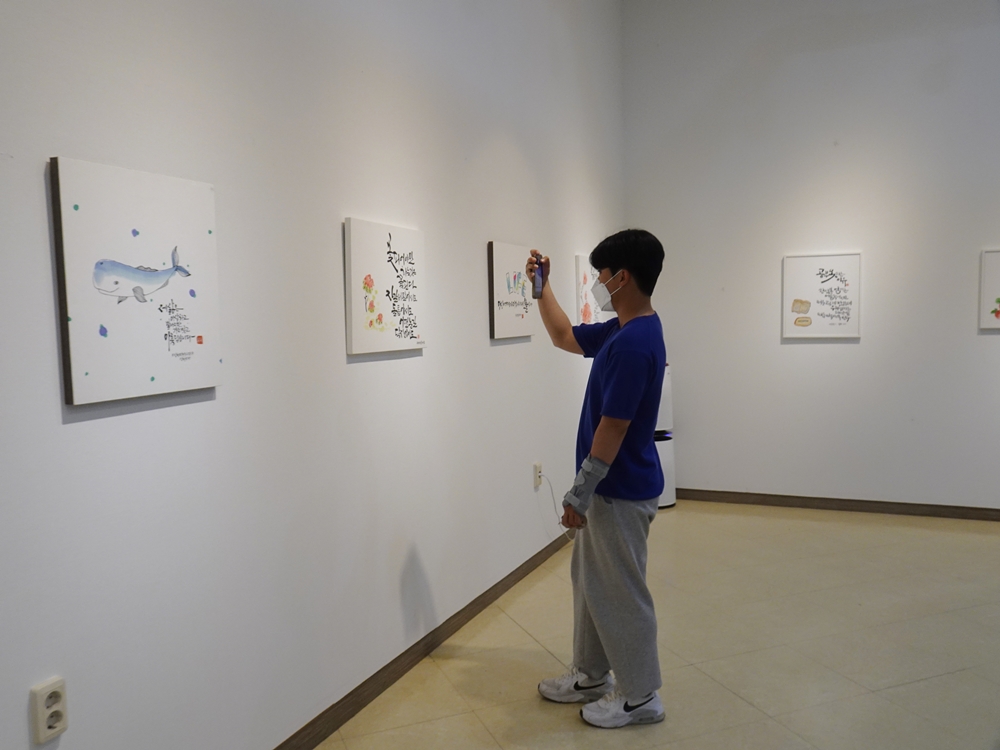 ▲ 전시회를 찾은 관람객이 작품을 카메라에 담고 있다.